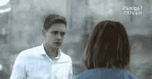 a man and a woman are looking at each other .