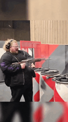 a man wearing headphones and goggles is holding a gun
