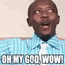 a man in a blue shirt and tie is making a surprised face and saying oh my god wow .