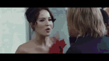 a woman in a red dress is talking to a man .