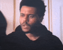 a man with a beard is standing next to a woman and talking to her .