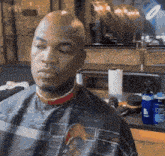 a bald man is getting his hair cut by a barber in a barber shop