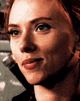 a close up of a woman 's face with red hair and blue eyes