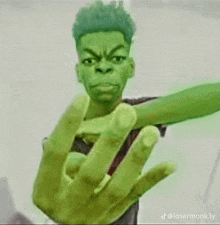 a young man with a green hand is making a middle finger sign .