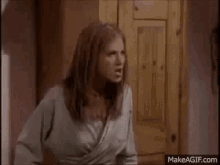 a woman is standing in front of a wooden door .