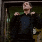 a man in a suit is dancing in a doorway while a woman watches .