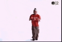 a man in a red shirt and a hat is dancing .