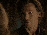a close up of a woman 's face with a man in the background