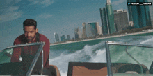 a man on a boat with a city in the background and the words pranay varma on the bottom