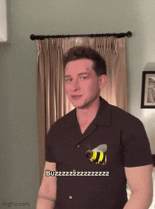 a man wearing a shirt with a bee on it says buzz