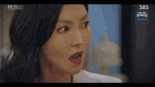 a close up of a woman 's face with a sbs logo in the background