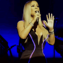 a woman singing into a microphone with the name mariah carey written below her