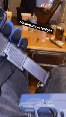 a person is holding a gun in front of a table that says making plays tonight on it