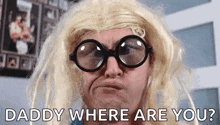 a man wearing glasses and a blonde wig is making a funny face .