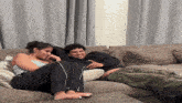 a woman sits on a couch next to a man