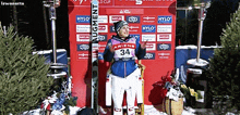 a woman wearing number 34 stands in front of a wall with advertisements for hylo