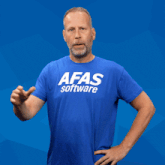 a man wearing a blue afas software shirt stands with his hands on his hips