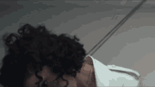 a woman with curly hair is tied up with rope