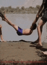 a man in a blue swim trunks is being held up by another man