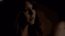 a close up of a woman 's face in the dark with a serious look on her face .