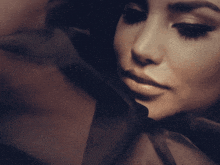 a close up of a woman 's face with a shadow behind her