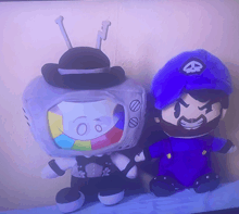 two stuffed toys are sitting next to each other one of which is a tv with the number 60 on it