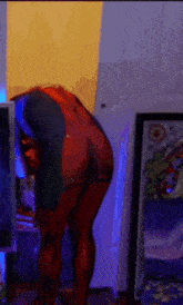 a person in a body painted spiderman costume is standing in a room