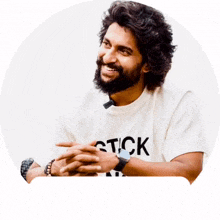 a man with a beard is wearing a white shirt that says stick on it