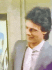 a man in a suit and tie is smiling