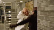 a man in a white suit is fighting another man in a red suit