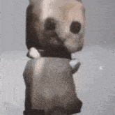 a statue of a cat with a collar on its neck is standing on a white surface .