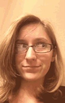 a close up of a woman wearing glasses making a funny face .