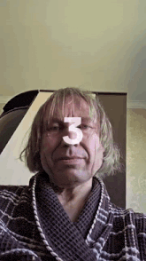 a man in a bathrobe with the number 3 on his face .