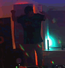 a man is dancing in a dark room with a disco ball behind him .