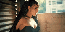 a woman with braids is wearing a black dress