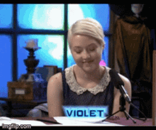 a woman sitting in front of a microphone with a shirt that says violet on it