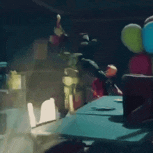 a bunch of balloons are on a table in the dark