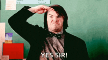 a man in a bow tie salutes in front of a chalkboard while saying yes sir .