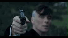 a man is holding a gun to his head .