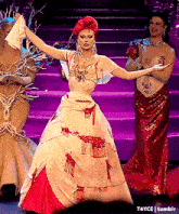 a drag queen in a white and red dress is dancing on a stage