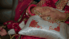 a woman in a pink dress holds a pillow with hearts on it