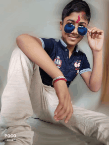 a young boy wearing sunglasses and a shirt that says raw on it