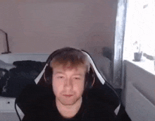 a man wearing headphones is sitting in a chair in a room .