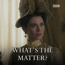 a woman is wearing a hat and earrings and says what 's the matter