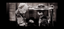 two anime characters are standing next to each other holding hands .