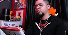 a man wearing glasses and a black shirt is looking at a puzzle book