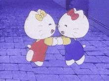 two hello kitty characters are hugging each other on a brick walkway .