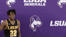 a man in a lsua jersey stands in front of a purple background