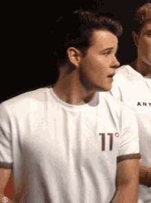 a man wearing a white shirt with the number 11 on the front