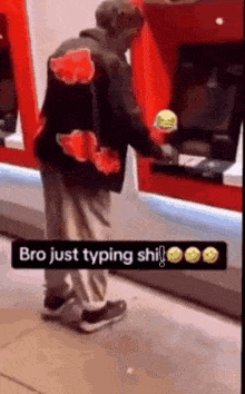 a man is standing in front of an atm machine and typing .